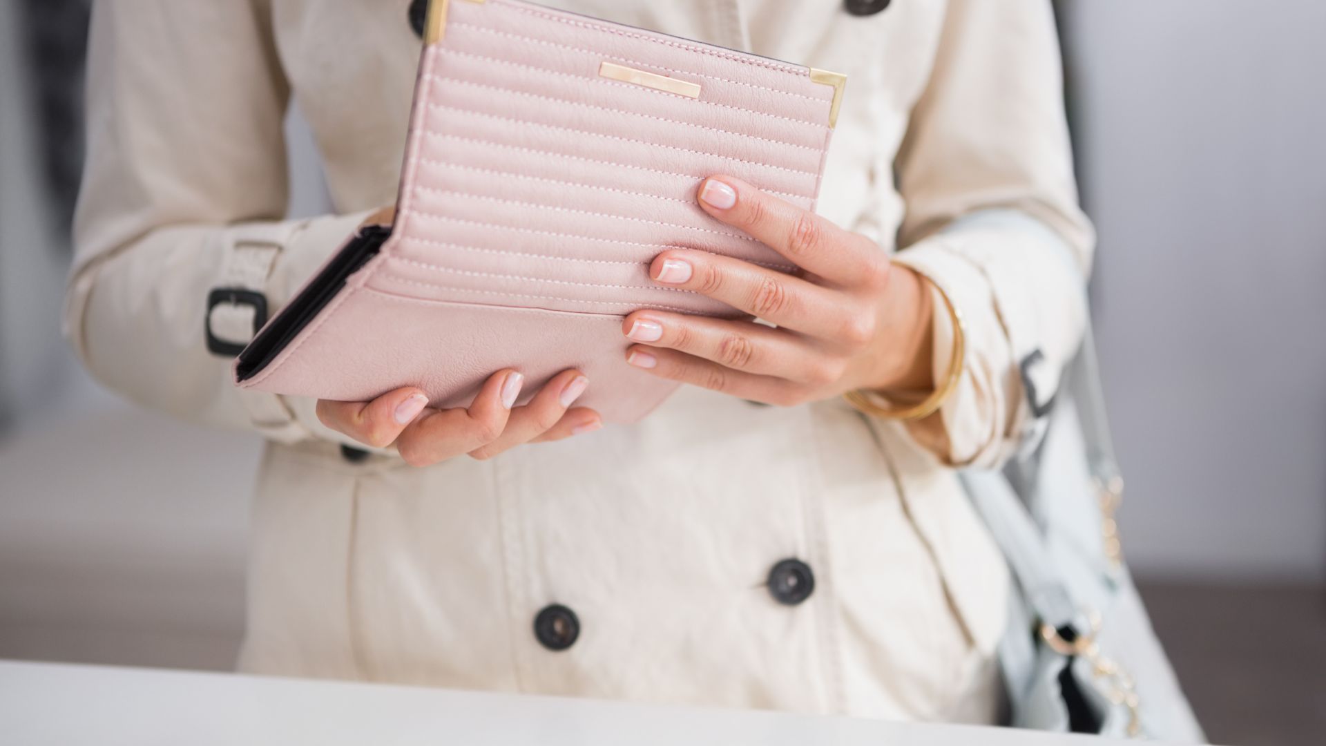 różowy portfel w rękach kobiety
